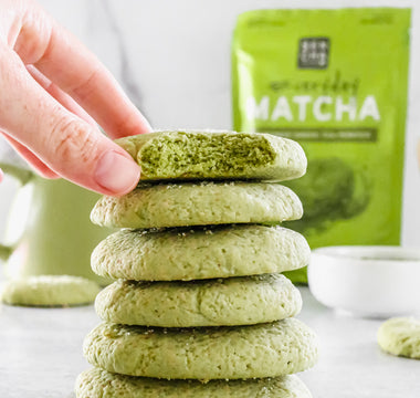 Photo of stacked sugar cookies baked with matcha green tea powder on a white background